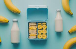 Fresh and colorful lunch boxes with fruits and sandwiches on a light blue background photo
