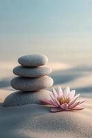 Tranquil scene with stacked stones and a blooming lotus flower on soft sand at dawn photo