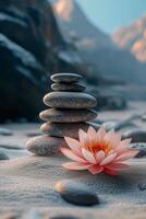 Tranquil scene with stacked stones and a blooming lotus flower on soft sand at dawn photo