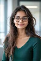 Young woman with long hair and glasses smiling confidently indoors in a bright and modern space photo
