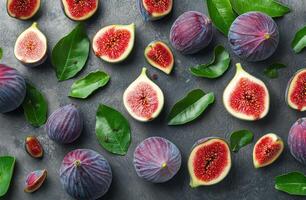 Fresh figs and green leaves arranged on a dark surface, creating a vibrant natural display photo