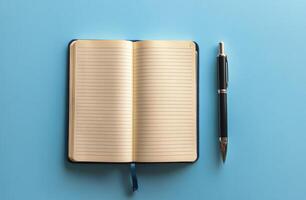A blank notebook and pen on a vibrant blue background waiting for creative thoughts photo