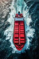 Aerial view of a cargo ship navigating through the ocean waves under bright sunlight photo