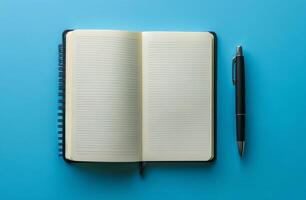 A blank notebook and pen on a vibrant blue background waiting for creative thoughts photo