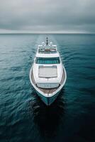 Luxury yacht cruising through calm waters under an overcast sky at sea photo