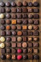 A diverse assortment of handcrafted chocolates arranged neatly on a wooden surface photo