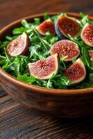 Fresh salad with sliced figs and prosciutto served in a wooden bowl on a dark wooden table photo