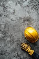 Construction worker placing yellow hard hat on textured gray wall in building site area photo