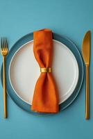 A beautifully set autumn themed dining table with orange leaves and elegant tableware photo