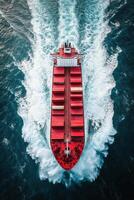 Aerial view of a cargo ship navigating through the ocean waves under bright sunlight photo