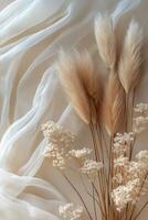 Soft beige flowers arranged gracefully on delicate fabric in a serene setting photo