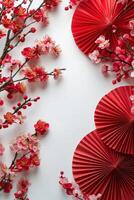 Decorative arrangement of cherry blossoms and red fans for celebration on a white background photo