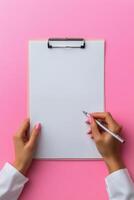 Writing notes on a clean clipboard with a pink background in a calm workspace setting photo