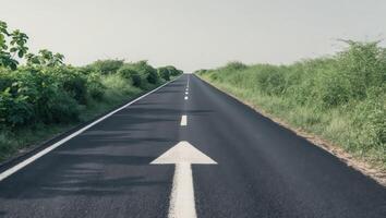 An empty road with an arrow pointing in the direction of the future photo