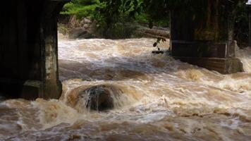 A strong current near a waterfall. Floods flowing in mountain rivers after heavy rains. Flash floods, the effects of global warming and the effects of deforestation. video