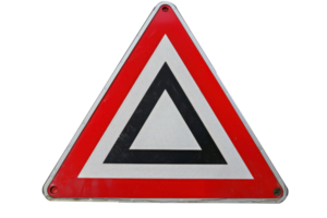 Close-up of a reflective triangular road sign warning drivers to yield, commonly found at intersections and road merges. png