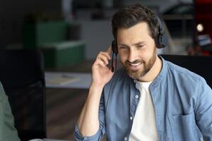 Smiling customer service agent working in busy call center photo