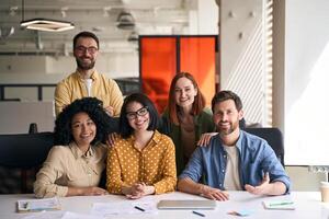 Group of diverse professionals smiling while working together in office photo