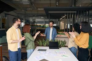 Diverse team applauding a colleague after a successful presentation photo