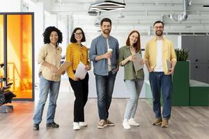 Group of five startup business people standing in office corridor smiling photo