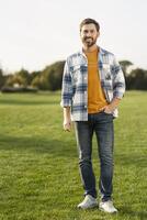 Handsome man smiling and standing in a field photo