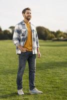 Handsome man smiling and posing in open field photo