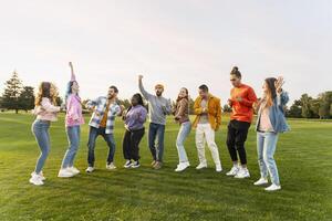 Group of friends dancing together in the park photo