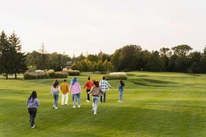 Group of friends walking on golf course celebrating event photo