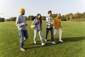 Four friends enjoying a lively conversation while walking in the park photo