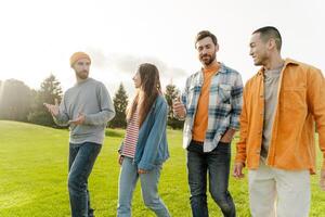 Group of friends walking and talking together in the park photo