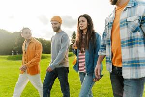 Group of friends walking and talking together in park photo