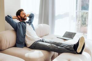 Smiling, happy Hispanic woman lying on comfortable sofa at home, relaxing after work at home photo