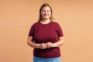 Positive beautiful plus size woman looking at camera in studio photo