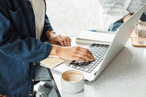 Freelancer working remotely from coworking space typing on laptop keyboard photo