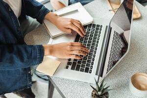 Freelancer working remotely from coworking space typing on laptop keyboard photo
