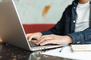 Freelancer working remotely from coworking space typing on laptop keyboard photo
