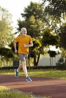 Senior man running in a park maintaining healthy lifestyle photo