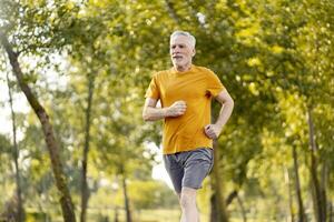 Senior man enjoying running in the park during summertime photo