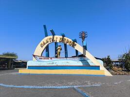 Monument at the entrance to Depok beach, Bantul, where fishermen sell marine products in the form of fish, shellfish, crabs, shrimp and lobster. photo