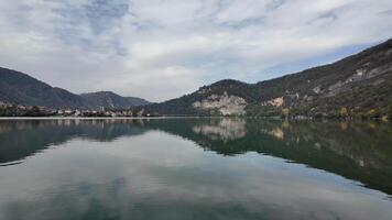 Scenic view of a tranquil lake surrounded by lush mountains, ideal for nature retreats and Earth Day reflections video