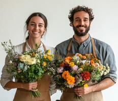 Young couple proudly holding colorful bouquets in a bright floral shop during daytime photo