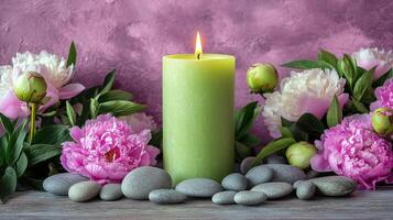 Serene green candle surrounded by peonies and smooth stones on a wooden table in a tranquil setting photo