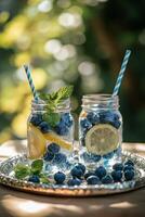 Refreshing blueberry lemonade served in mason jars with fresh mint outside on a sunny day photo