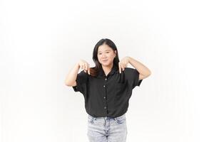 beautiful Asian woman smiles brightly while pointing downward, set against a clean white background photo