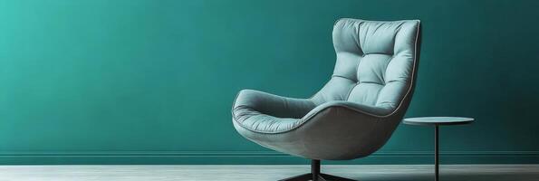 Cozy corner with a vintage armchair and small wooden table against a textured blue wall photo