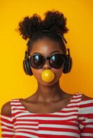 Young girl with headphones blowing bubble gum against a bright yellow background photo