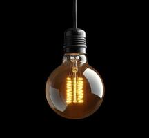 A vintage style light bulb illuminated against a dark background showcasing warm glow photo