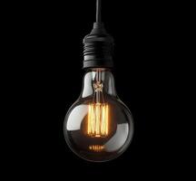 A vintage style light bulb illuminated against a dark background showcasing warm glow photo