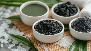 Three bowls of natural mineral powders displayed on a bamboo mat surrounded by lush green foliage photo