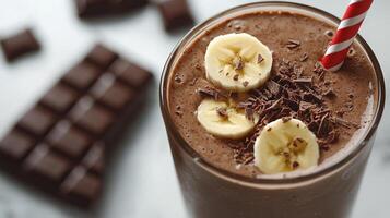 Delicious chocolate milkshake topped with chocolate shavings and a red striped straw photo